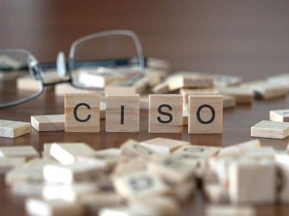 Desk with reading glasses and Scrabble tiles spelling CISO