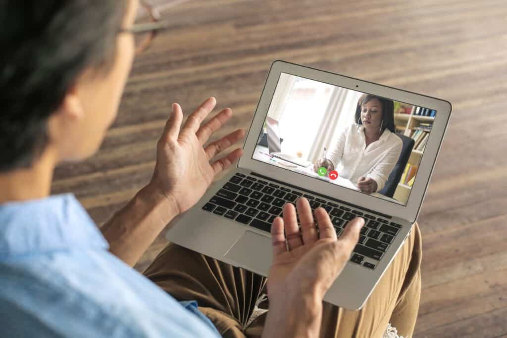 Photo of two women talking over a video conference on a laptop