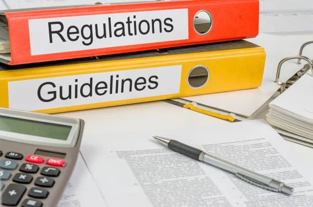Image of stacked binders labeled "regulations" and "guidelines"