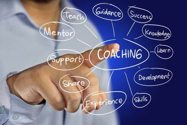 Man pointing at marker board with word cloud containing coaching descriptions